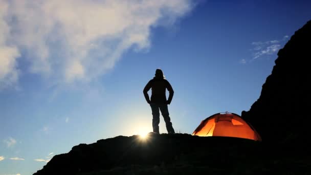 Femme randonneuse en silhouette à flanc de montagne à l'aube — Video