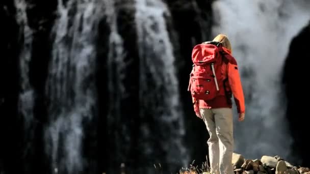 女性登山者休息在一个瀑布 — 图库视频影像