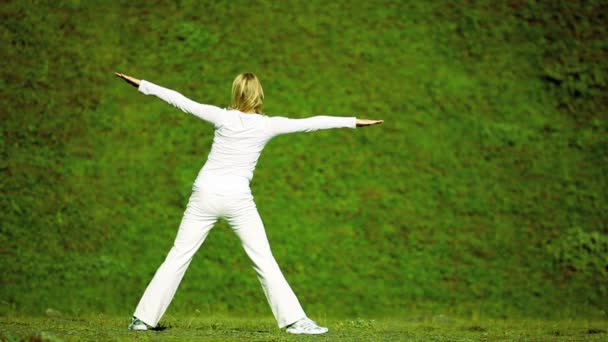 Женщина в белой исполнительской йоге — стоковое видео