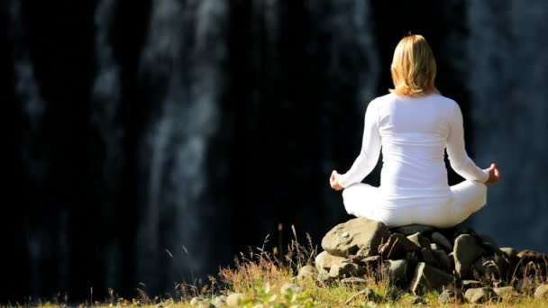 Frauen praktizieren Yoga am Wasserfall — Stockvideo