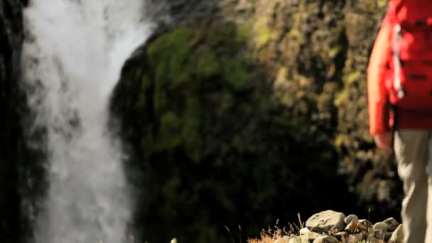 Caminhante feminina atingindo uma cachoeira glacial — Vídeo de Stock