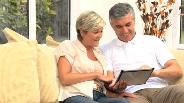 Středního věku pár pomocí bezdrátové tablet — Stock video