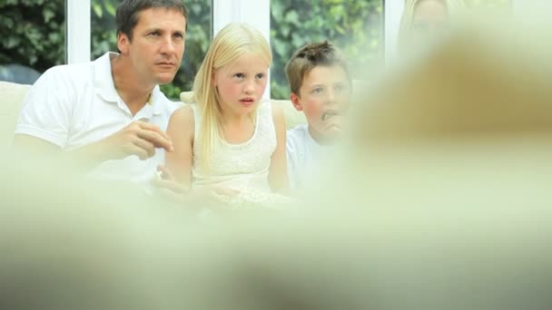 Atractiva familia disfrutando de TV y palomitas de maíz — Vídeos de Stock