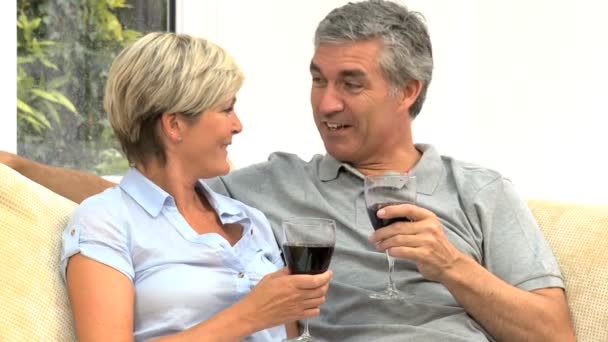 Pareja caucásica de mediana edad en casa bebiendo vino tinto — Vídeo de stock