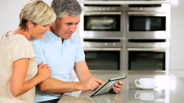 Ouder paar draadloos tablet met keuken — Stockvideo