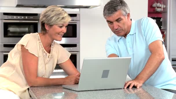 Mature Couple Using Wireless Latop in Home Kitchen — Stock Video