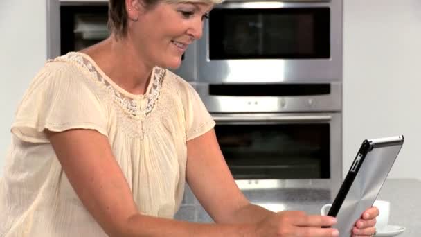 Chytrá dospělá samice pomocí bezdrátové tablet v kuchyni — Stock video