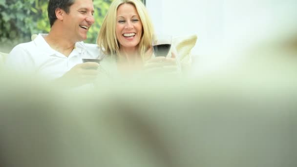 Atractiva pareja relajándose en casa bebiendo vino — Vídeo de stock
