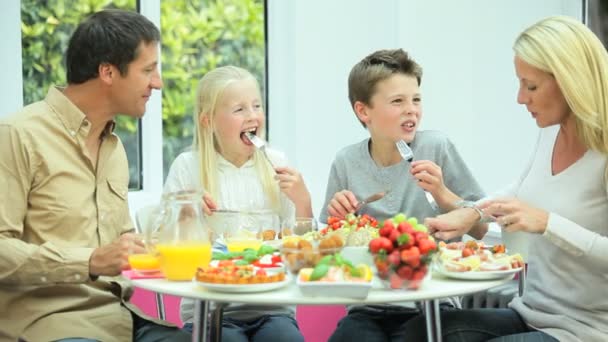 Atractiva familia joven disfrutando de una comida saludable — Vídeos de Stock