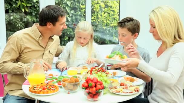 Молодая семья наслаждается здоровым питанием — стоковое видео
