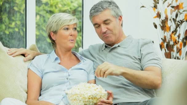 Mature Couple Eating Popcorn in Front of TV — Stock Video