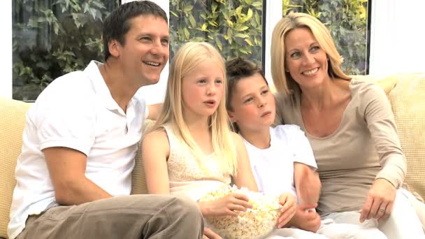 Joven familia viendo película junto con palomitas de maíz — Vídeos de Stock