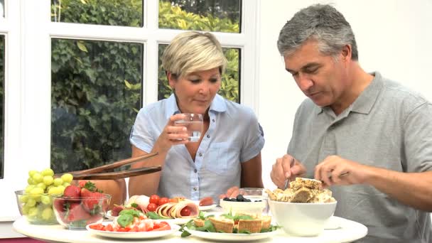 Paar mittleren Alters bereitet gesundes Mittagessen zu — Stockvideo