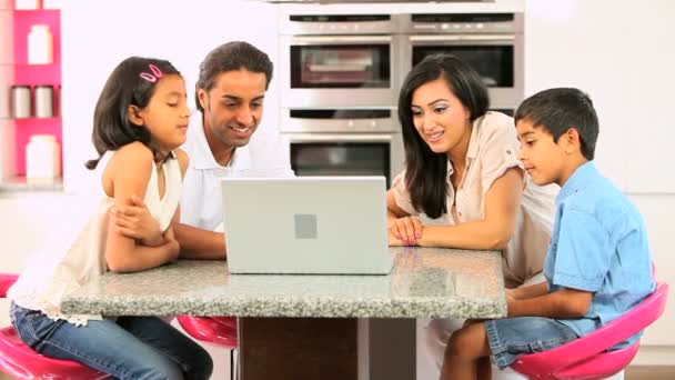 Jeune famille ethnique avec ordinateur portable dans la cuisine — Video