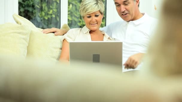 Paar mittleren Alters benutzt Laptop zu Hause — Stockvideo