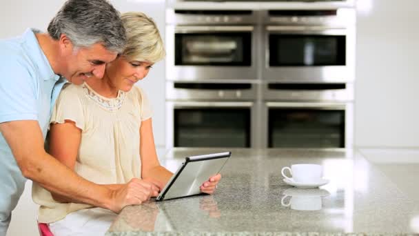 Kablosuz tablet kullanılarak evde mutfakta Olgun çift — Stok video