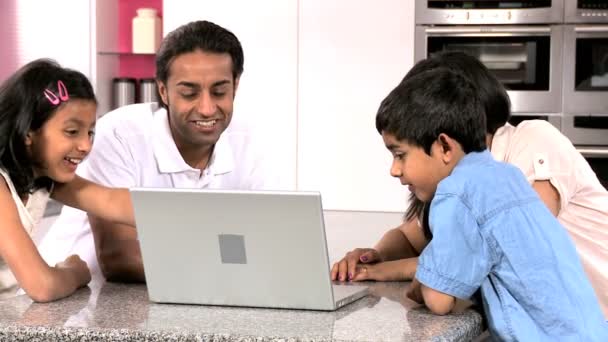 Молодая азиатская семья с ноутбуком на кухне — стоковое видео