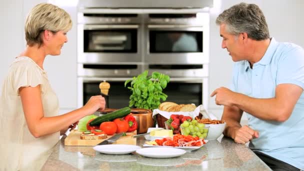 Ältere Paare in der heimischen Küche bereiten Mittagessen zu — Stockvideo