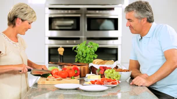 Pareja de mediana edad preparando un almuerzo saludable — Vídeo de stock