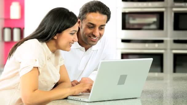 Casal asiático atraente na cozinha com laptop — Vídeo de Stock