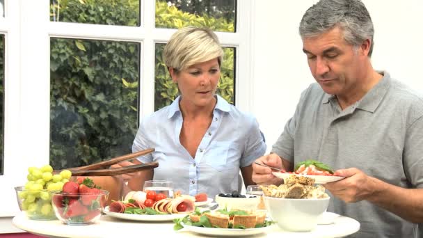 Casal de meia-idade comendo alimentos frescos saudáveis — Vídeo de Stock