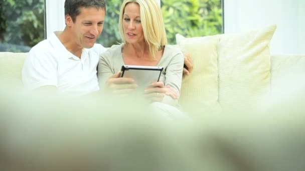 Casal jovem caucasiano usando tablet sem fio em casa — Vídeo de Stock