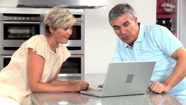 Middle Aged Caucasian Couple in Home Kitchen Using Laptop — Stock Video