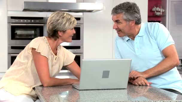 Ouder paar draadloze laptop; deze keer met eigen keuken — Stockvideo