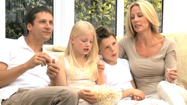 Atractiva familia disfrutando de TV y palomitas de maíz — Vídeo de stock