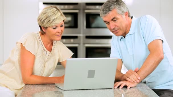 Middle Aged Caucasian Couple in Home Kitchen Using Laptop — Stock Video