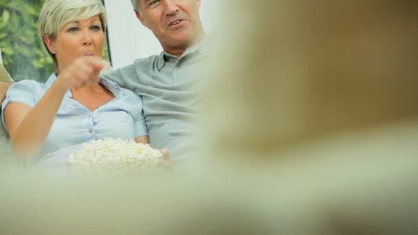 Pareja caucásica madura disfrutando de la televisión y las palomitas de maíz — Vídeo de stock