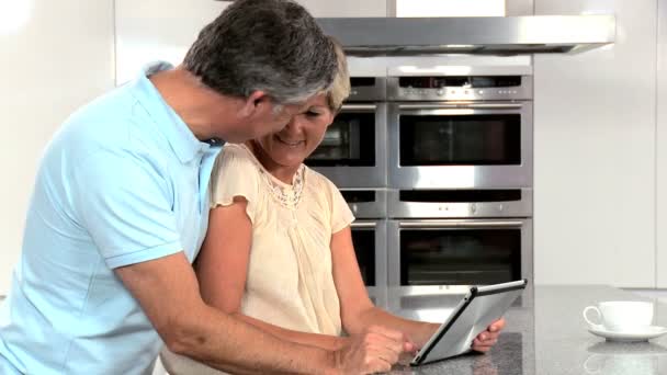 Зріла пара використовуючи бездротовий планшет на кухні — стокове відео