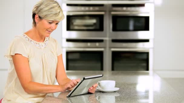 Maturo femmina utilizzando tablet wireless in cucina — Video Stock