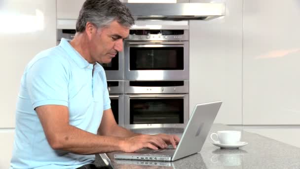 Зрелый мужчина с помощью ноутбука доволен результатами онлайн — стоковое видео