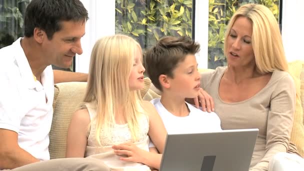 Giovane famiglia caucasica che utilizza il computer portatile sul divano — Video Stock