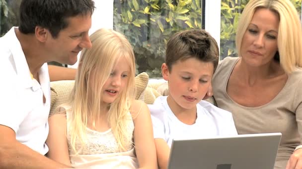 Familia caucásica en casa con computadora portátil — Vídeo de stock