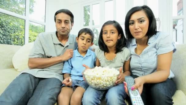 Joven familia étnica viendo televisión con palomitas de maíz — Vídeo de stock