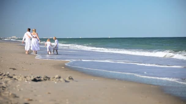 Kaukasische familie schoppen van een bal op strand — Stockvideo