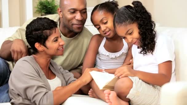 Pequeña niña étnica leyendo a la familia — Vídeos de Stock