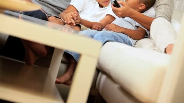 Junge ethnische Familie schaut gemeinsam fern — Stockvideo
