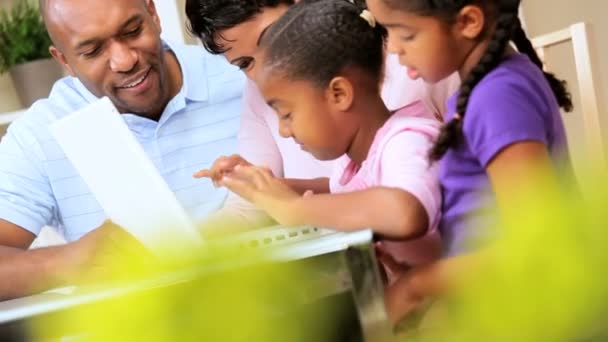 Orgulhosos pais étnicos assistindo filhas usando laptop — Vídeo de Stock