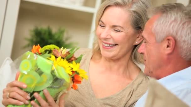 Madura dama con flores de marido — Vídeos de Stock