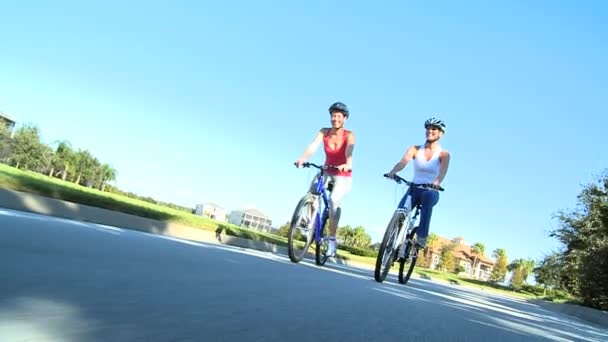 Past jonge vrouwelijke vrienden samen fietsen — Stockvideo