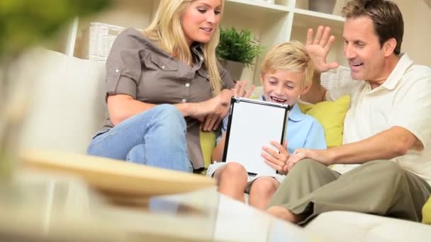 Familia joven usando la tableta inalámbrica para el chat de vídeo en línea — Vídeos de Stock