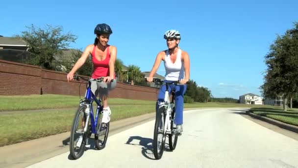 Zdolne młode przyjaciółki jeżdżące razem na rowerze — Wideo stockowe