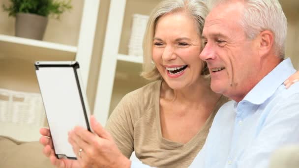 Äldre kaukasisk par använder en trådlös tablet hemma — Stockvideo