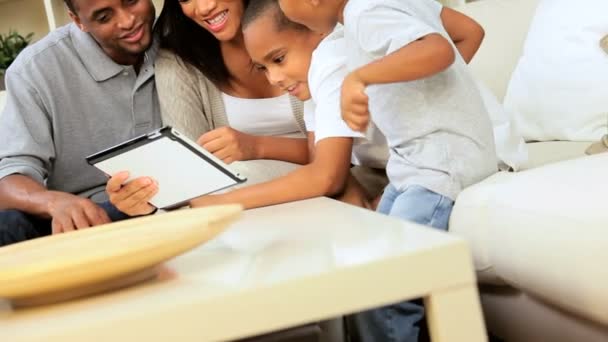 Familia joven en casa usando una tableta inalámbrica — Vídeos de Stock