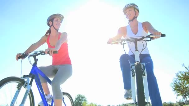 Caucásicas amigas ciclismo en las carreteras suburbanas — Vídeo de stock