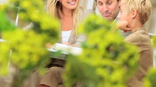 Young Caucasian Family Sitting with a Book — Stock Video