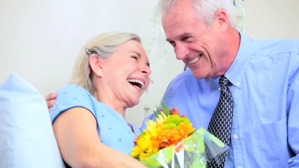 Старший леді в лікарні з квіточками чоловіків — стокове відео